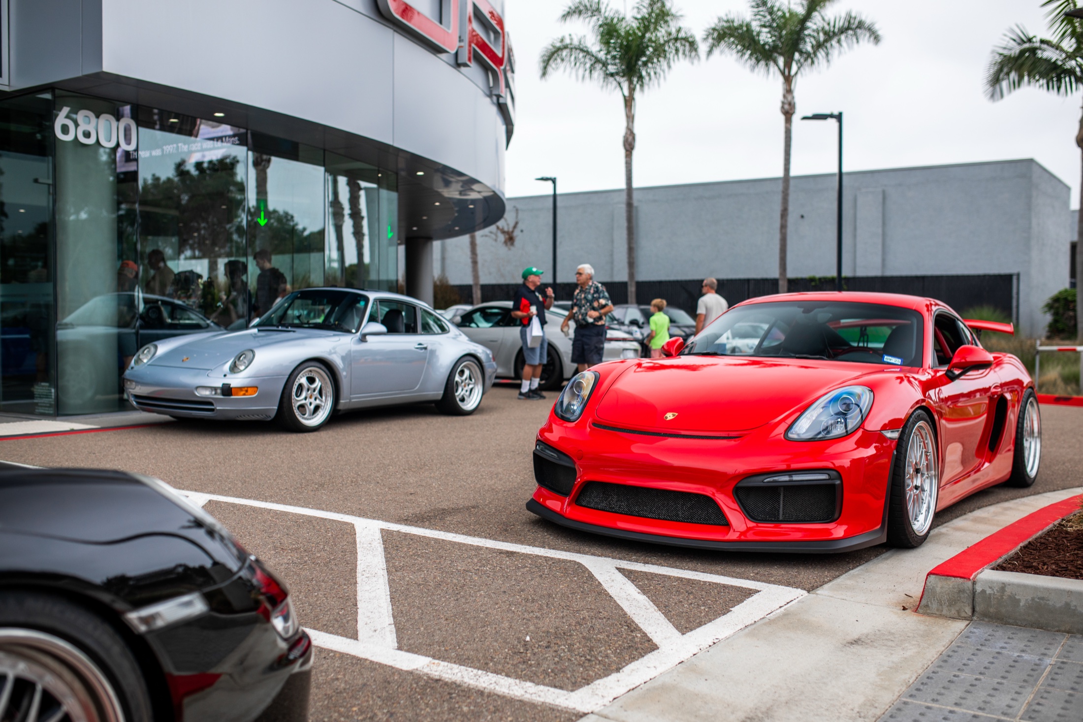 Cars lined up at the Porsche Carlsbad entrance as visitors arrive for Cars and Coffee