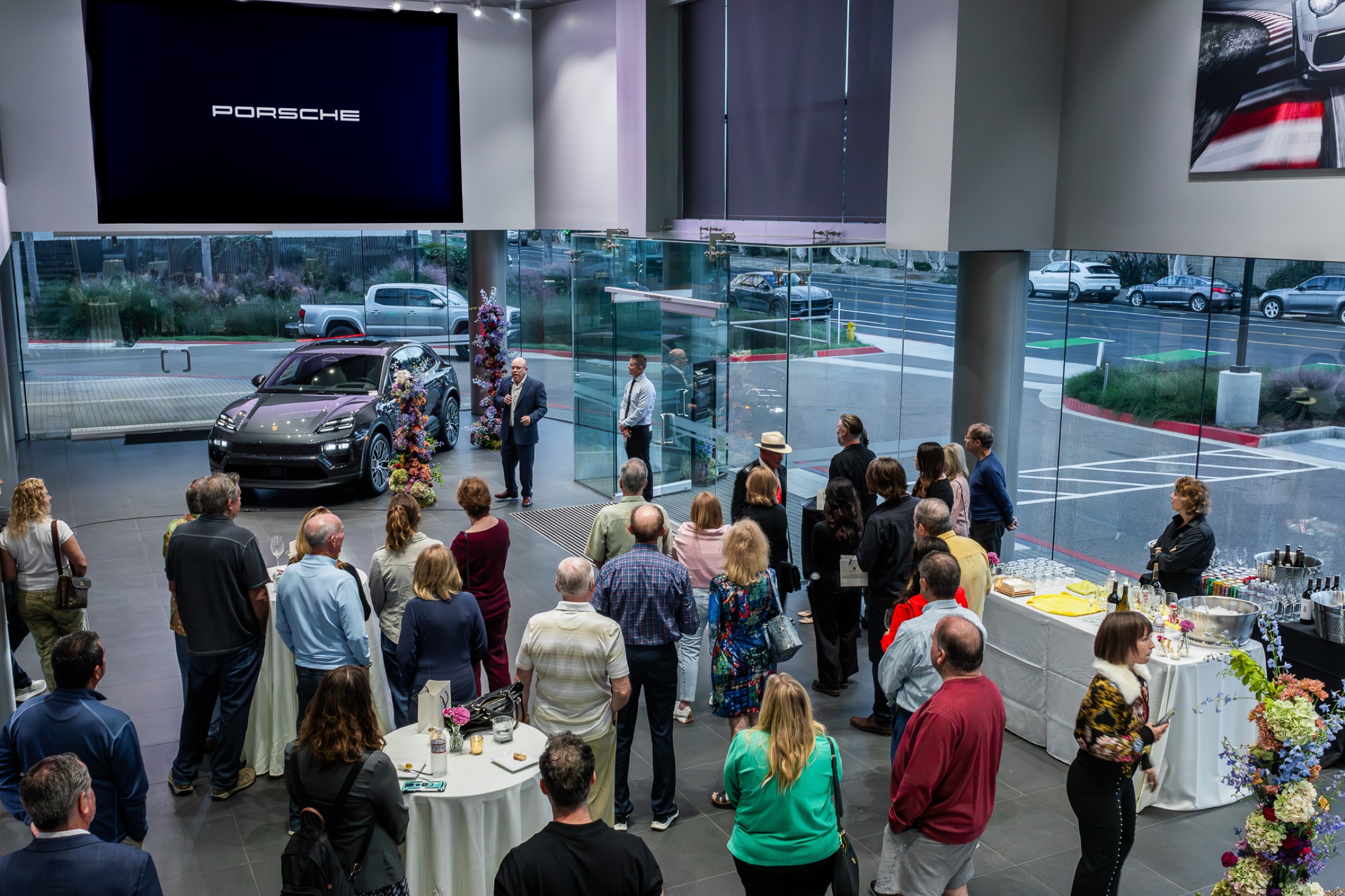 Guests gathered on the plaza at dusk during the Macan EV launch event