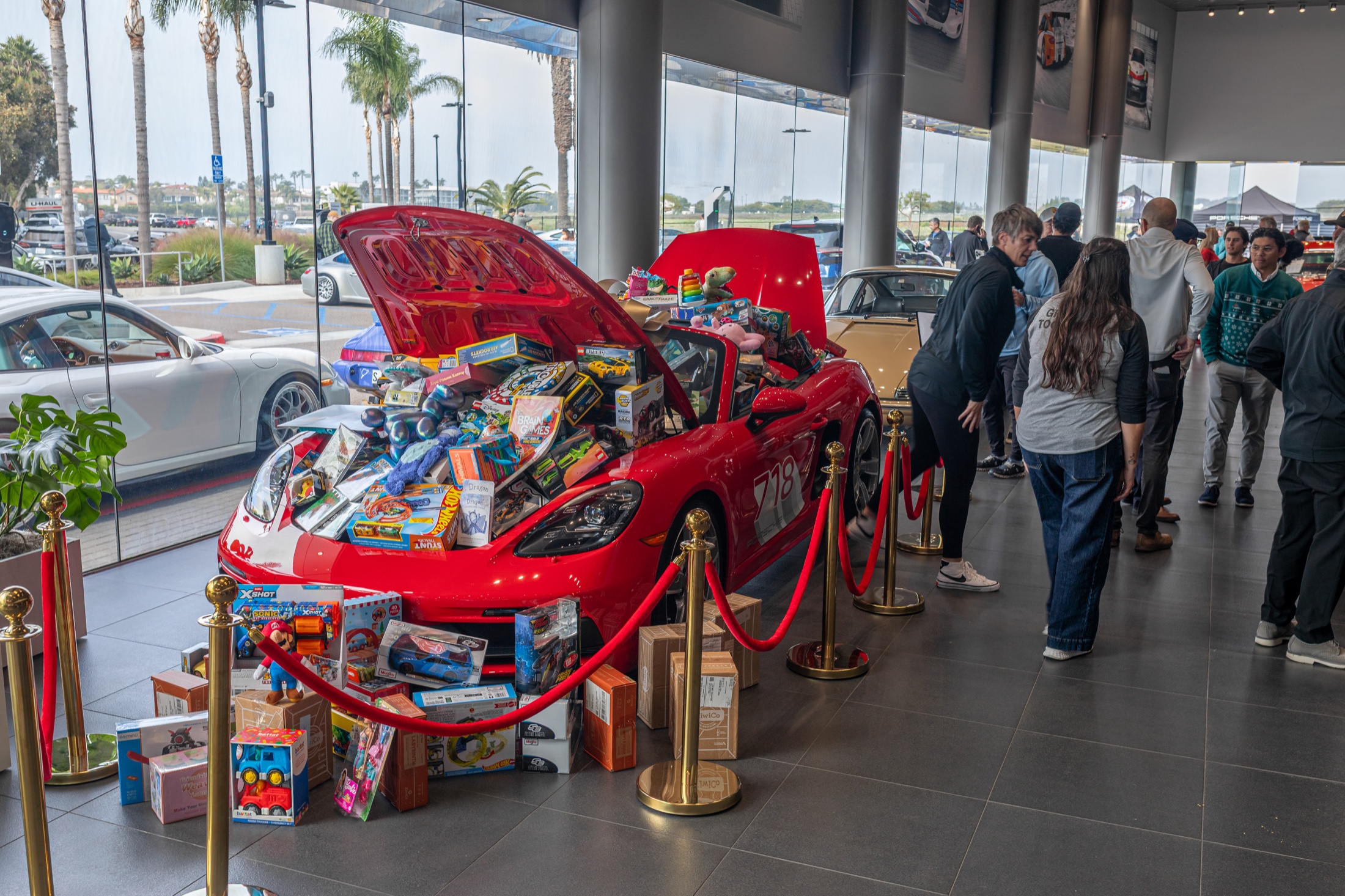Red 911 with its front trunk full of donated toys behind a red rope at the Porsche Carlsbad Toy Drive